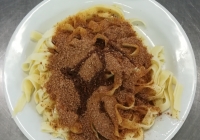 Těstoviny sypané perníkem a cukrem, maštěné máslem, ochucené mléko